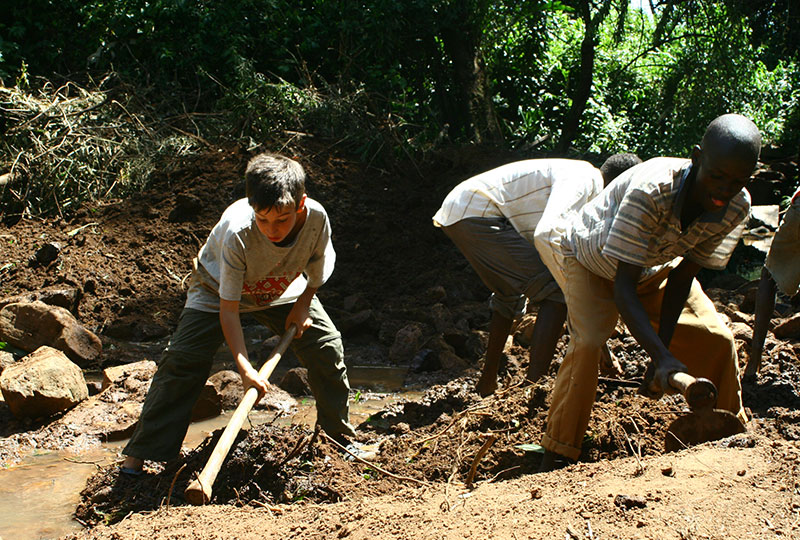 Paul Picado-Curtis and friend work to clear the site of a second underground water source.