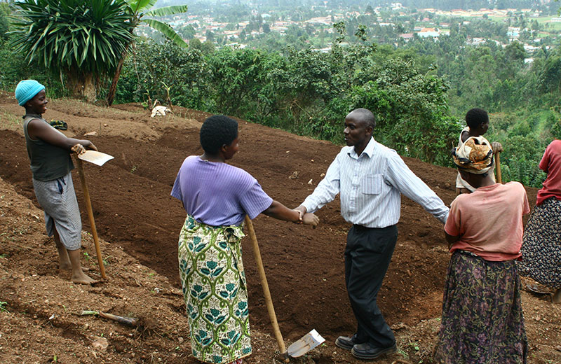 Pastor Edward Kanyesigye and women crew surveying and celebrating their work!
